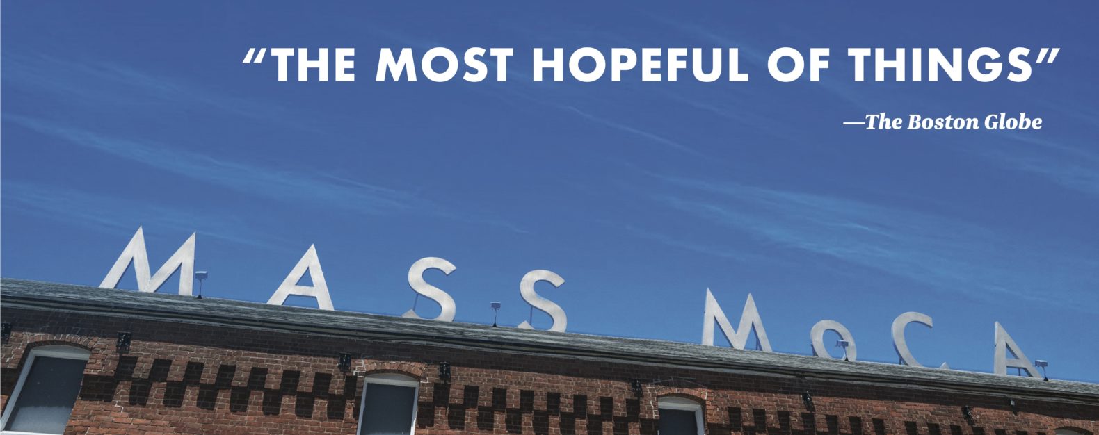 Angled up view of brick building with MASS MoCA sign and blue sky above, with text overlaid reading "The most hopeful of things"