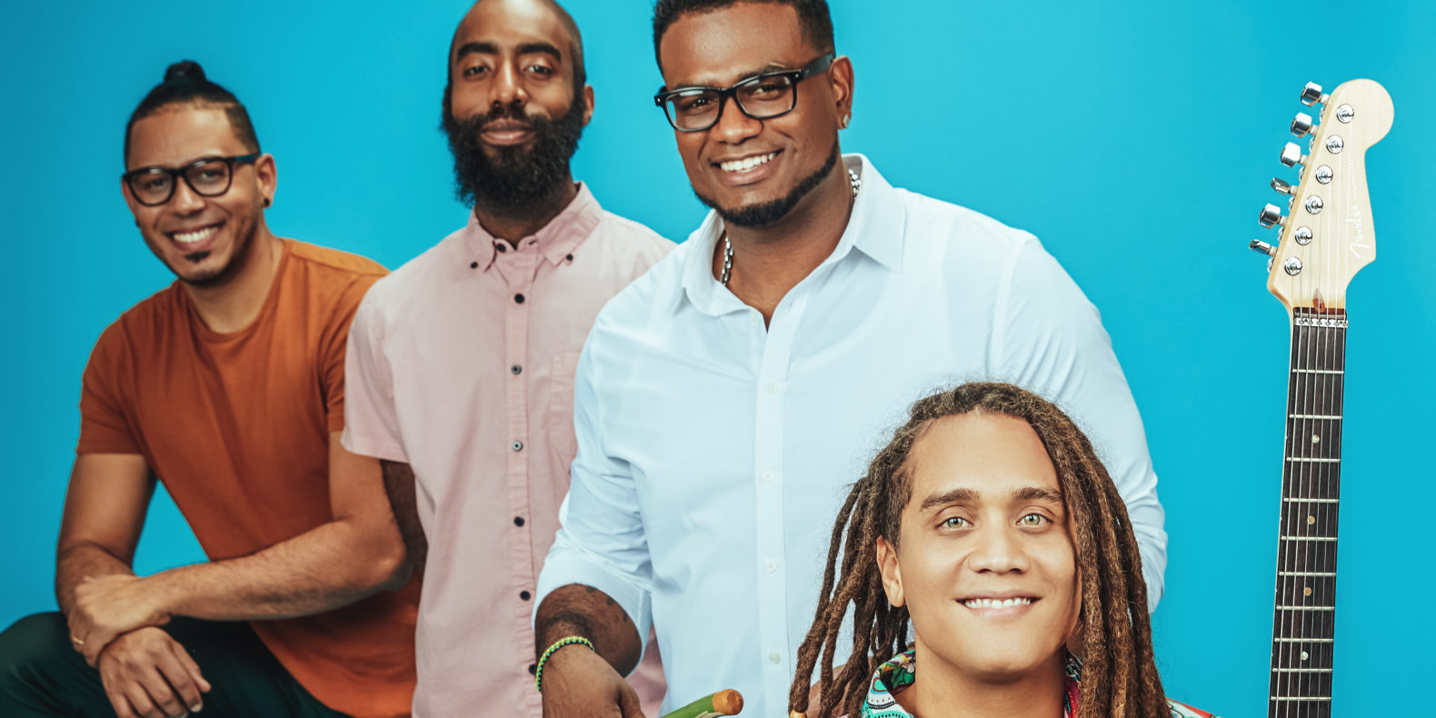 Yasser Tejeda and their three person band, against a blue background