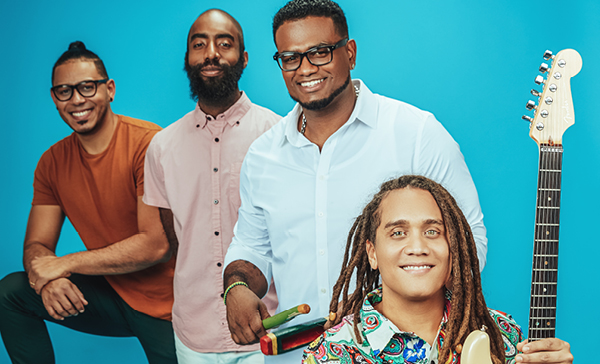 Yasser Tejeda and their three person band, against a blue background