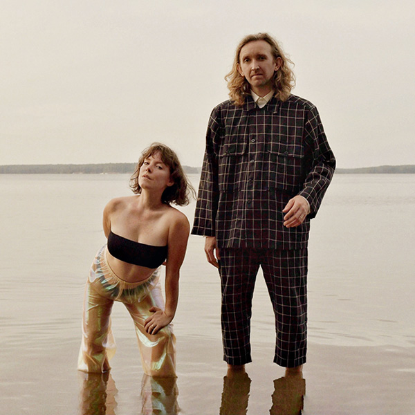 Sylvan Esso, singer Amelia Meath and producer Nick Sanborn, standing in a lake
