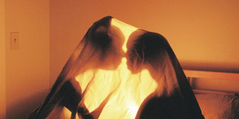 Close to You feature image, two people illuminated under a sheet