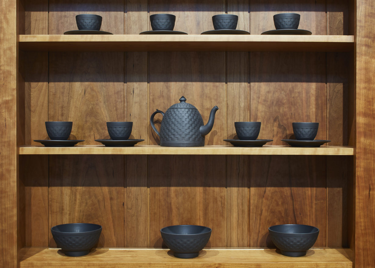 Lapsed Quaker Ware feature image, Black ceramics dishes on a wooden shelf