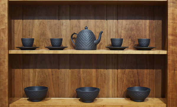 Lapsed Quaker Ware feature image, Black ceramics dishes on a wooden shelf