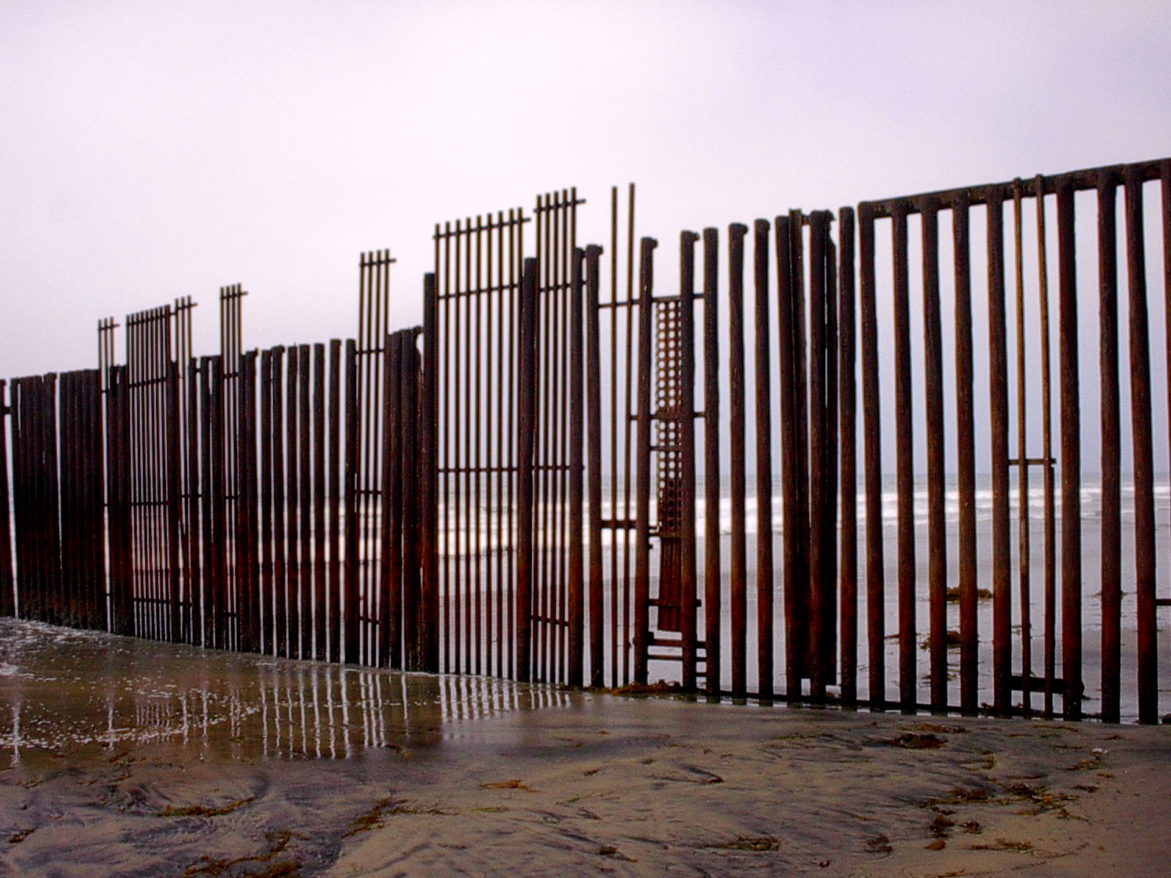3 Familiar Gazes from/at the USA-Mexico Border feature image, metal US-Mexico border fence on beach