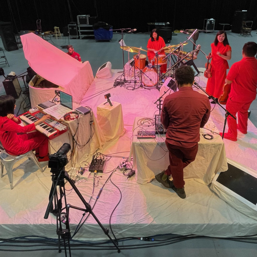Yuka Honda & Susie Ibarra featured image, musicians dressed in red on white stage