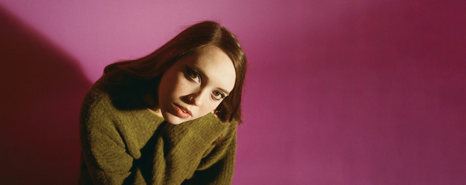 Soccer Mommy feature image, Soccer Mommy in front of pink wall