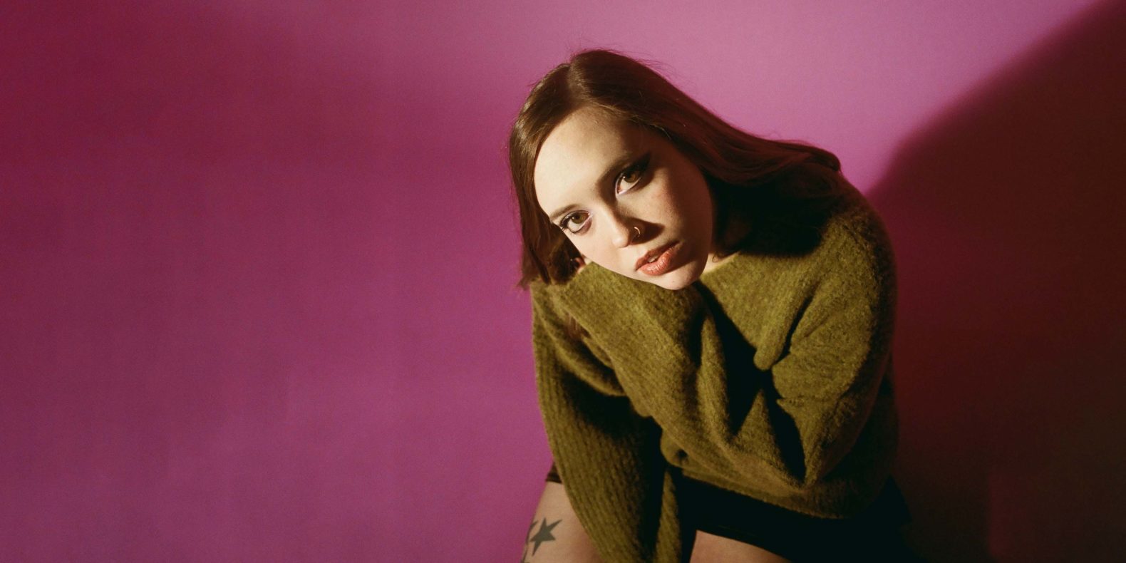 Soccer Mommy feature image, Soccer Mommy in front of pink wall